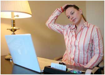 Woman stretching her neck while sitting at a desk